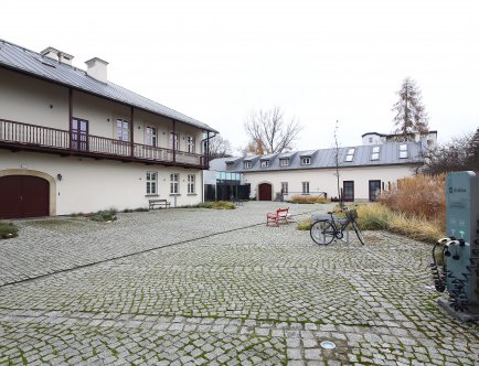 Kolorowa fotografia przedstawiająca budynek Muzeum Podgórza oraz jego najbliższe otoczenie.